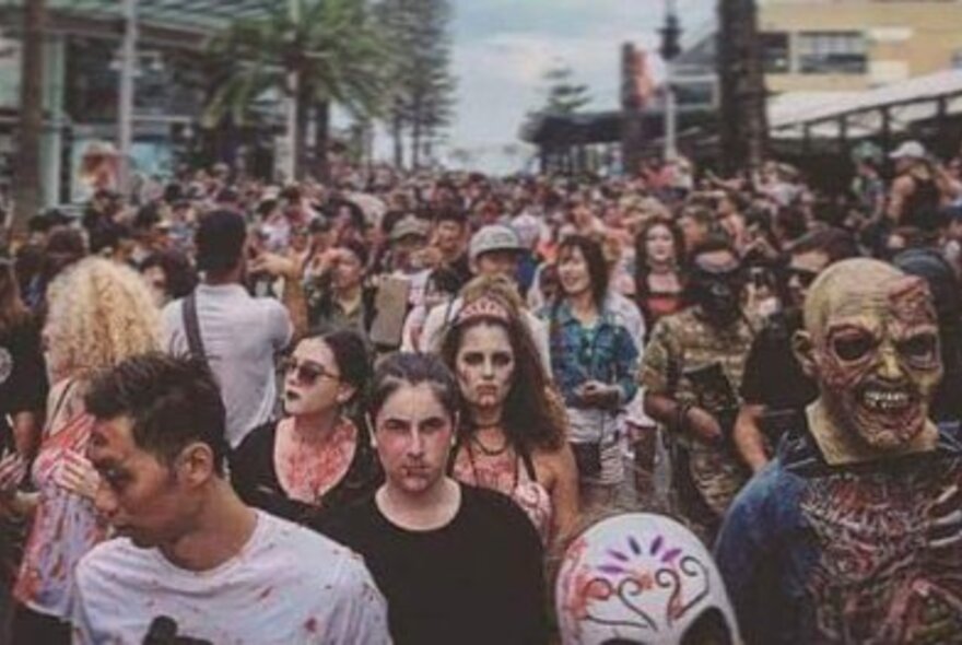 People in zombie costume participating in a zombie walk in a city street.