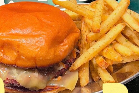 Close up of a burger with fries.