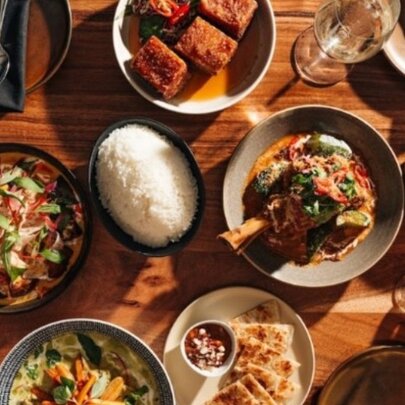 Overhead view of a table with assorted dishes of food, drinks and cutlery.