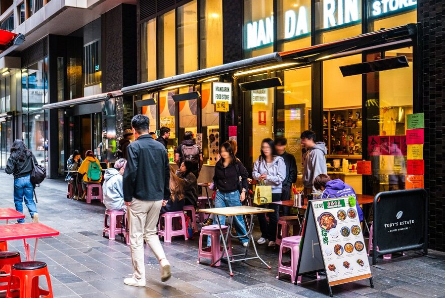 A busy casual restaurant with colourful seats in a laneway.