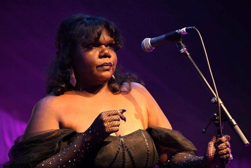 Singer Eleanor Jawurlngali standing on stage in front of a microphone.