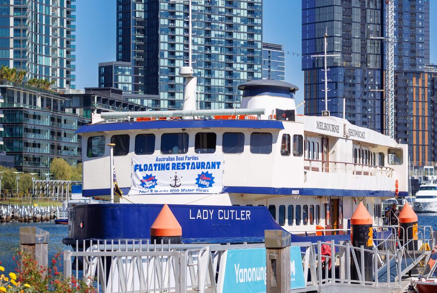 The Lady Cutler floating restaurant with city buildings in the background.