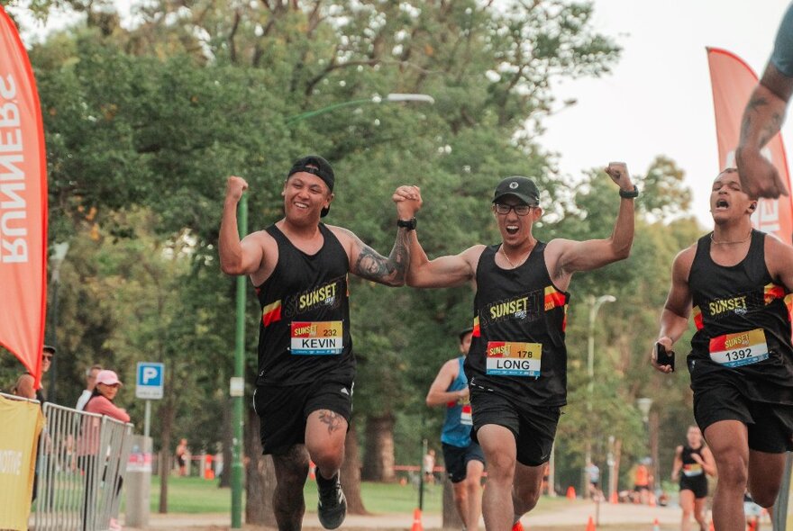 Joggers running along the Tan track, trees in the background.