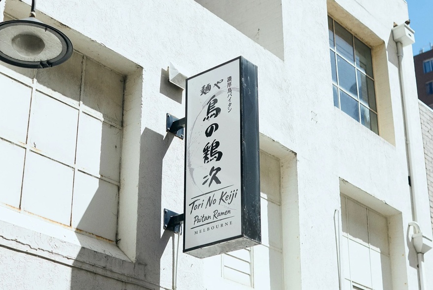 White building with signage for of Tori No Kenji restaurant.