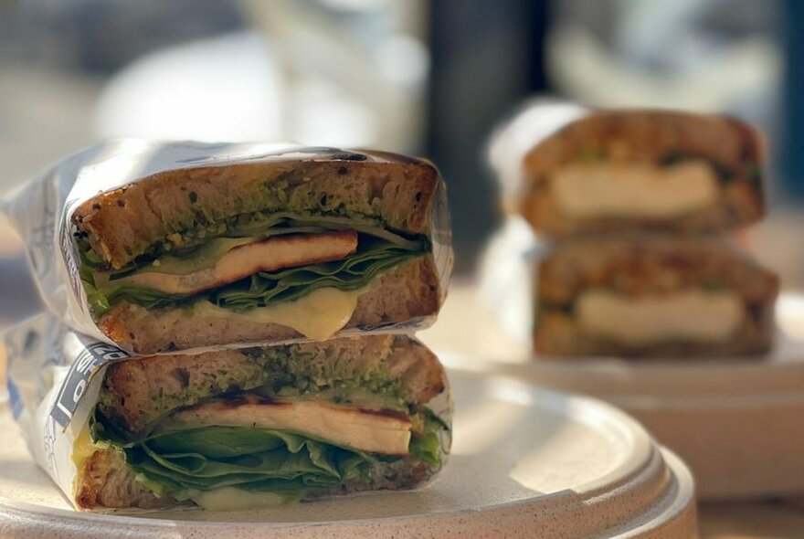 Cross section of two sandwiches stacked on top of each other on a plate.