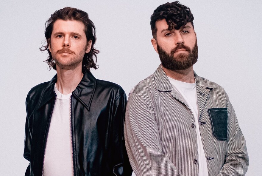 Two members of the electronic due Miami Horror, posing in front of a pale background.