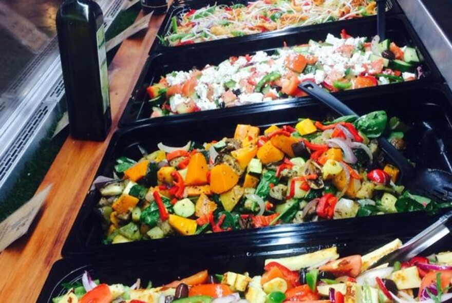 Several containers of various chopped salads.