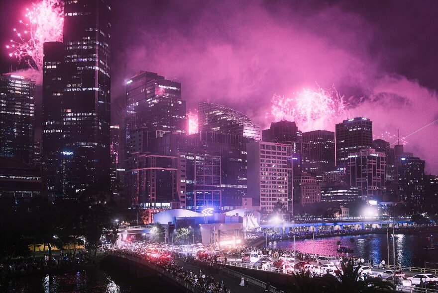 Melbourne's city skyline at night, lit up with bright pink fireworks.