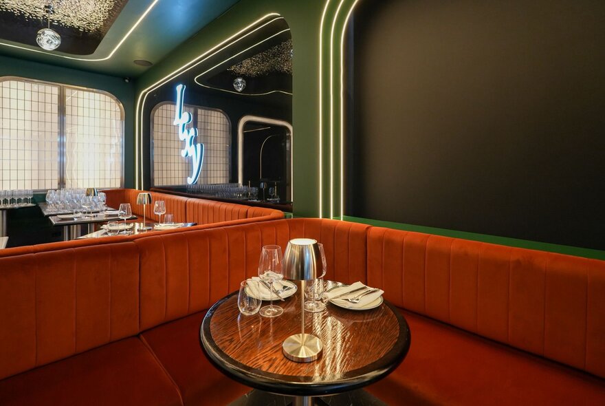 Red banquettes with round tables in an Asian-inspired bar.