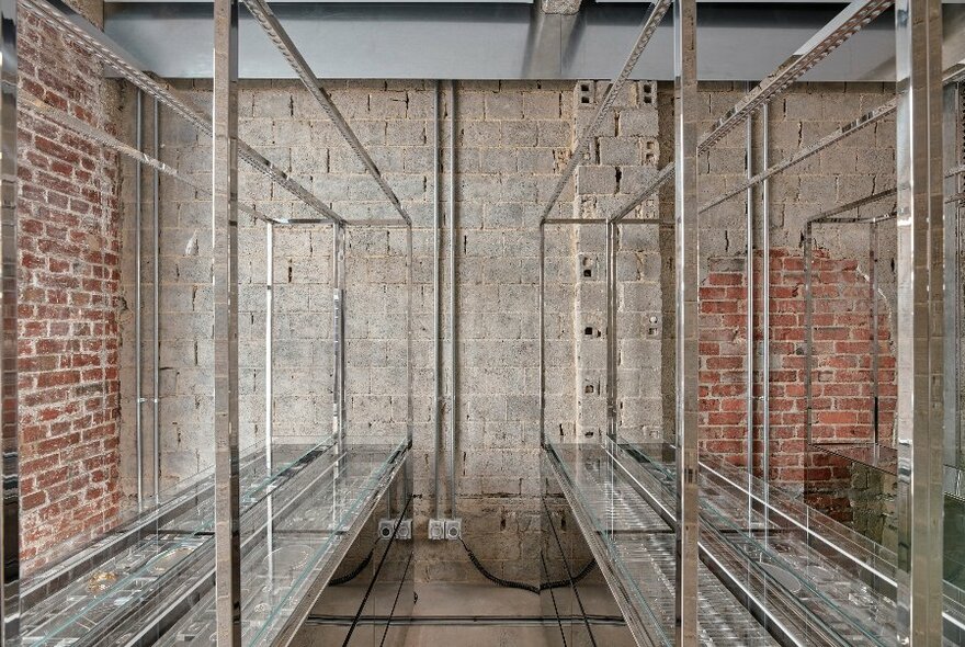 Interior of jewellery store with exposed red brick walls and glass displays of jewellery.