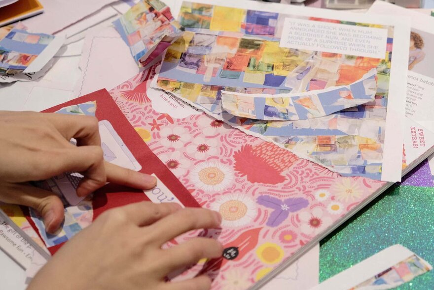 Hands holding paper and cards in a craft workshop.