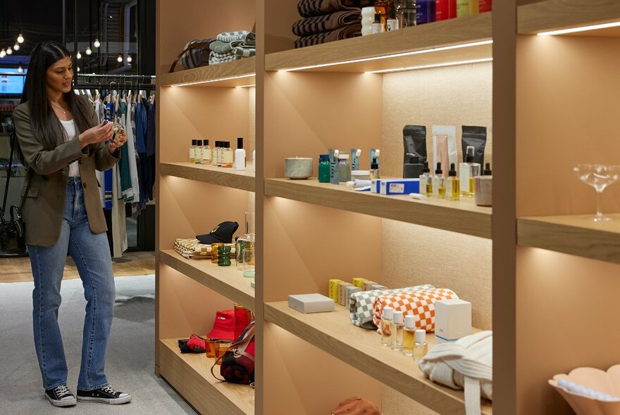 A woman browsing skincare in a boutique. 