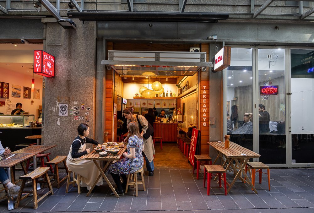 Warmly lit laneway restaurant with outdoor seating.