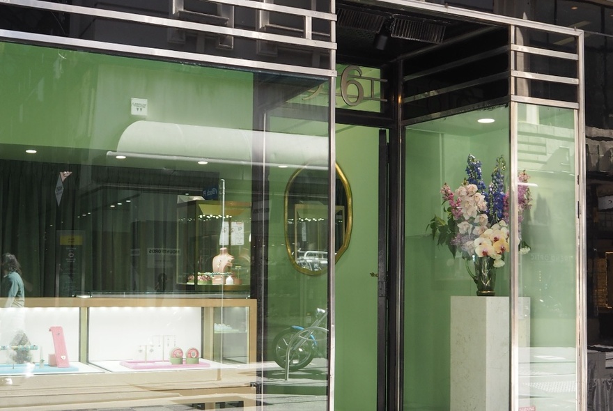 Exterior of Sarah Gardner fine jewellery store, with large glass windows and a bouquet of fresh flowers on a plinth near the entrance.