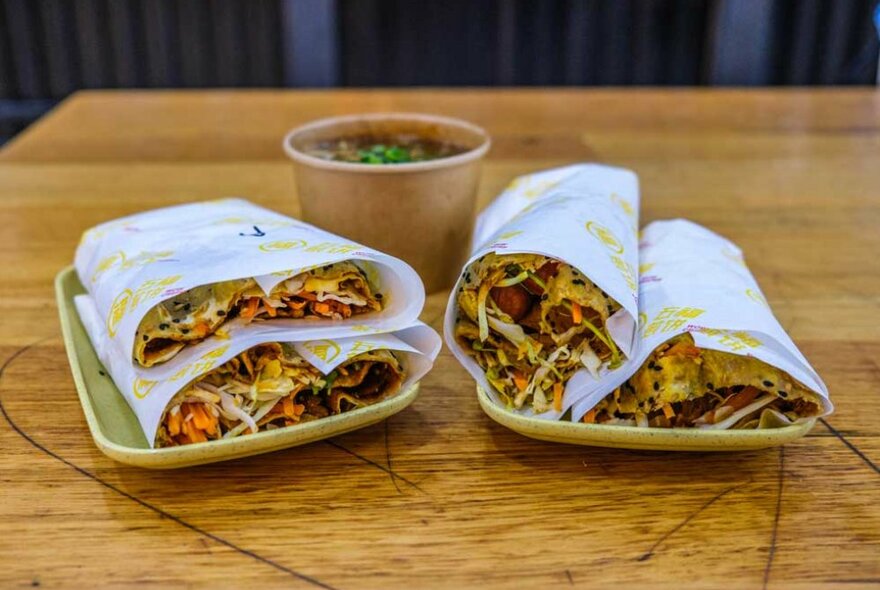 Two rolled flat wraps on a table in a food court