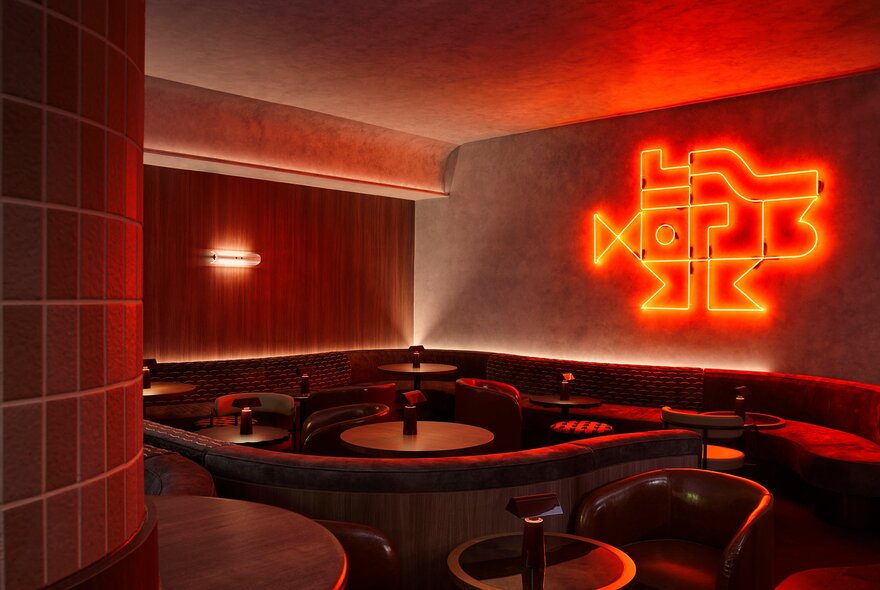 Booth and table seating in a corner of Mr Mills bar, with a red neon artwork on the wall.