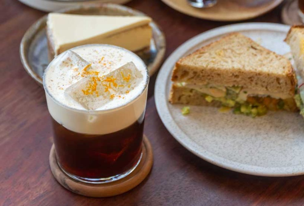 A glass of iced coffee with cream on top