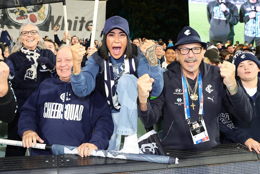 AFL footy fans cheering with their team's flags and banners in the stadium at MCG.
