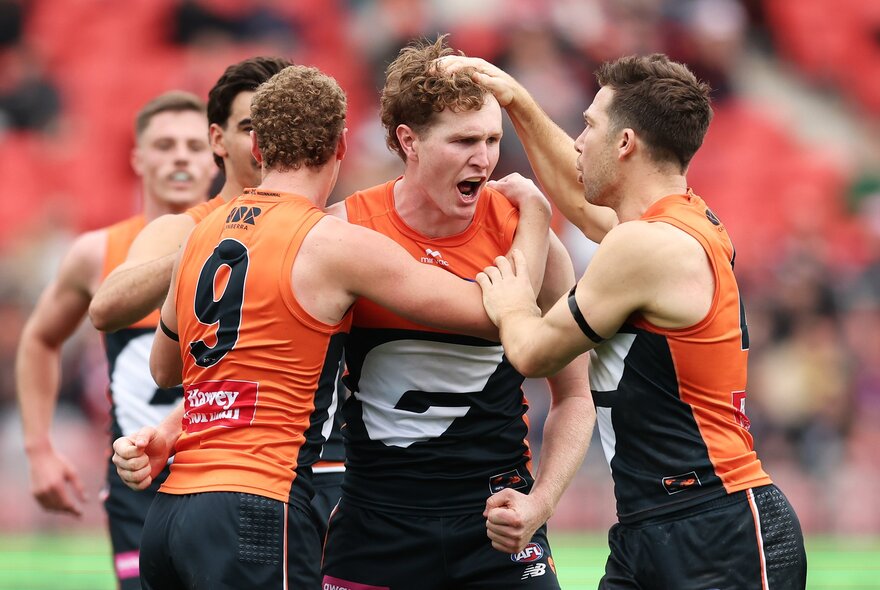 GWS Giants AFL football players on the field during a match.
