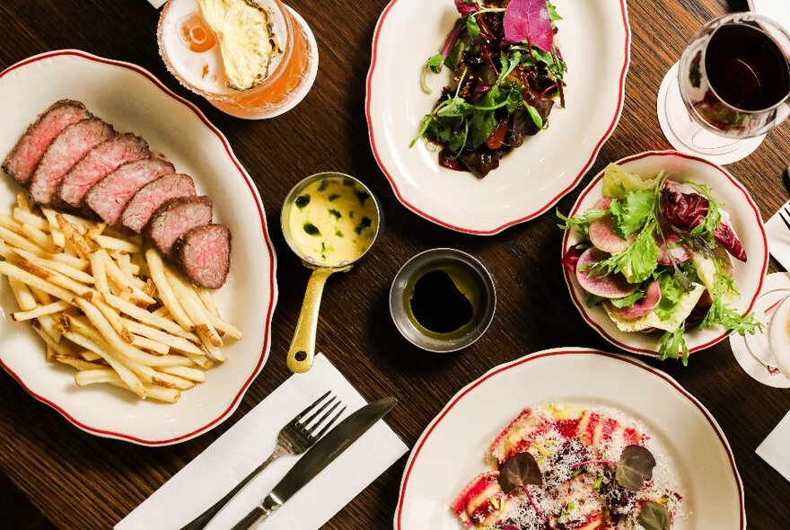 Looking down at a table full of plates of food and drinks. 