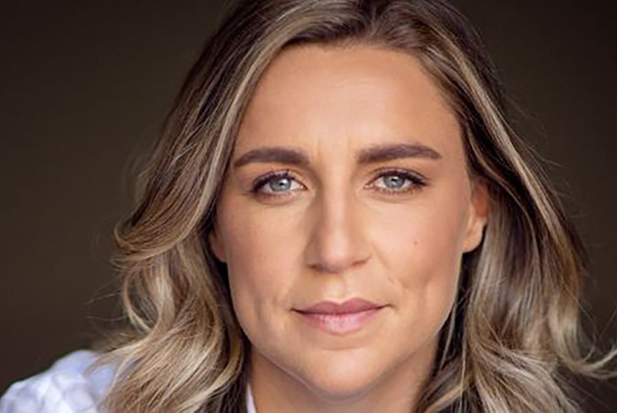 Head shot of Freya List, an Australian choreographer, with blond wavy hair framing her face.