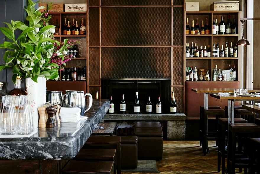 Sophisticated European restaurant with wine bottles on the shelves and glass carafes.