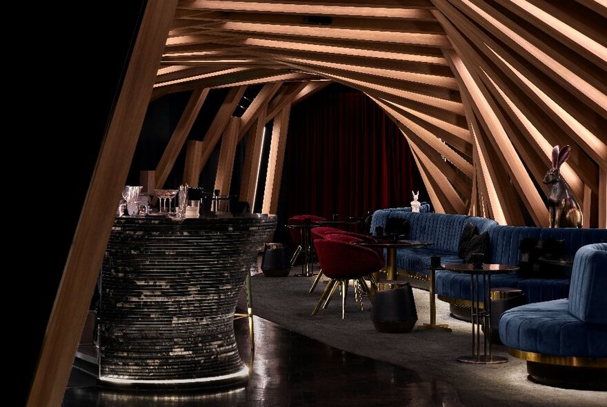 Interior of Curious Bar with a ribbed roof and blue sofas.