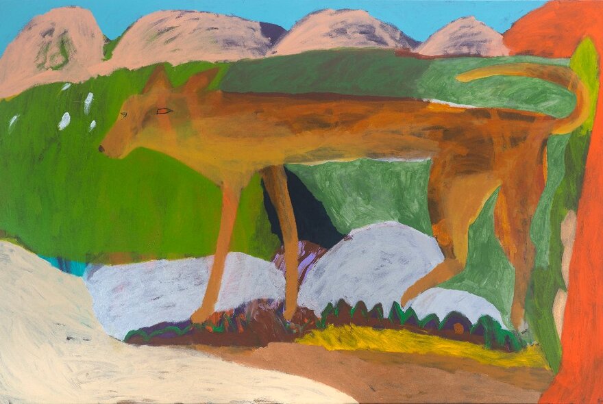 Oil painting of a dingo in a landscape with a mountain backdrop, in bold colours of green, brown and orange and painted in a naïve slightly primitive style. 