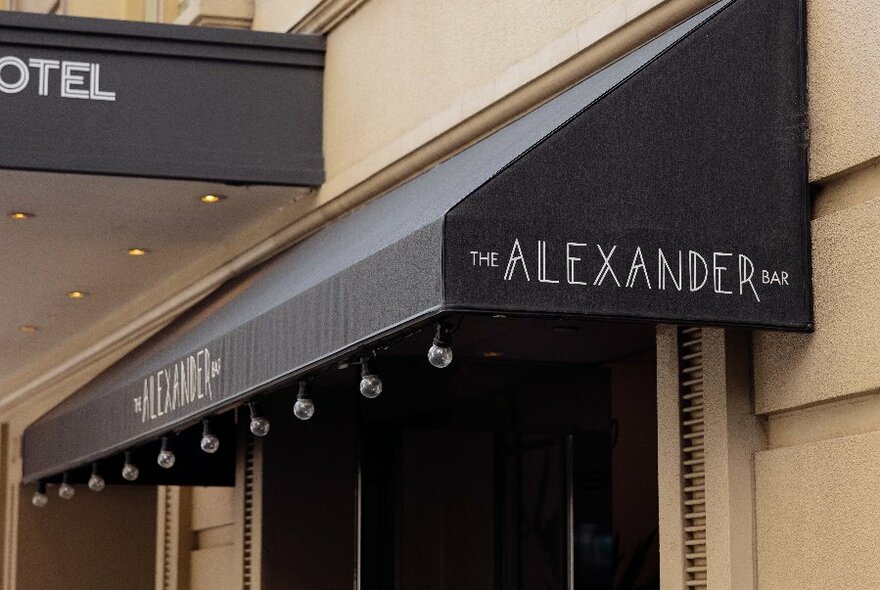 Exterior shade awning, wall and signage of The Alexander Bar.