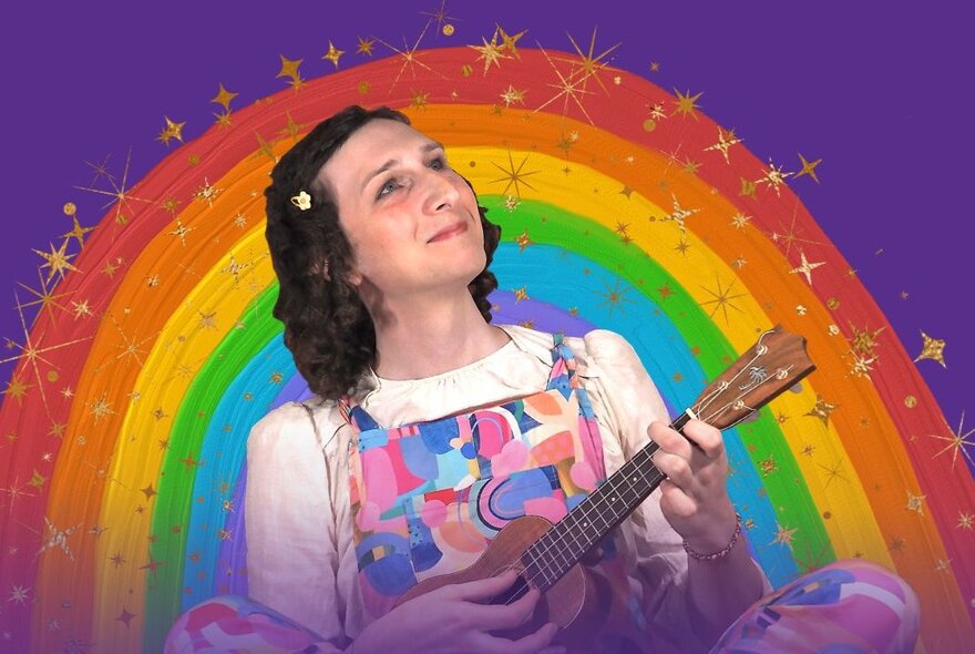 Children's entertainer playing a ukulele in front of a rainbow.