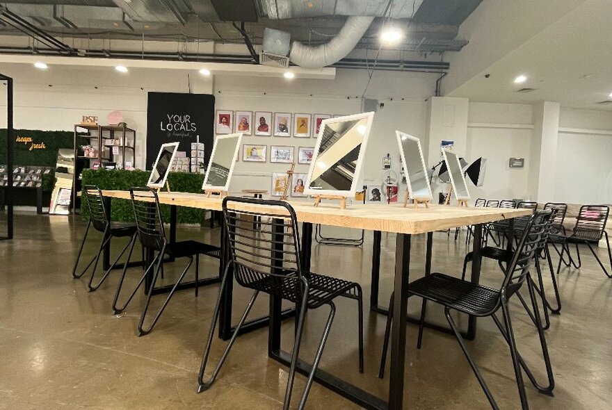 Interior of a gallery or studio space with chairs arranged around a work bench..