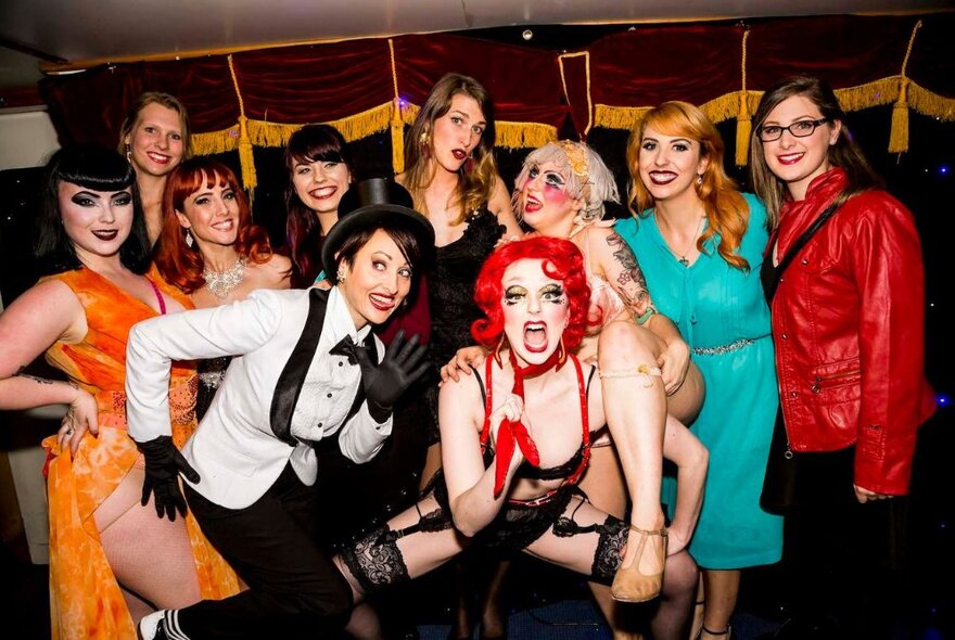 Group of people wearing burlesque outfits and makeup.