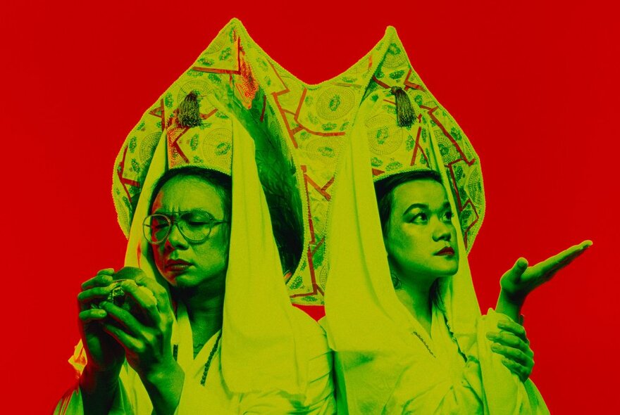 Two Chinese women shaded in green, wearing traditional robes and headdresses against a red background.