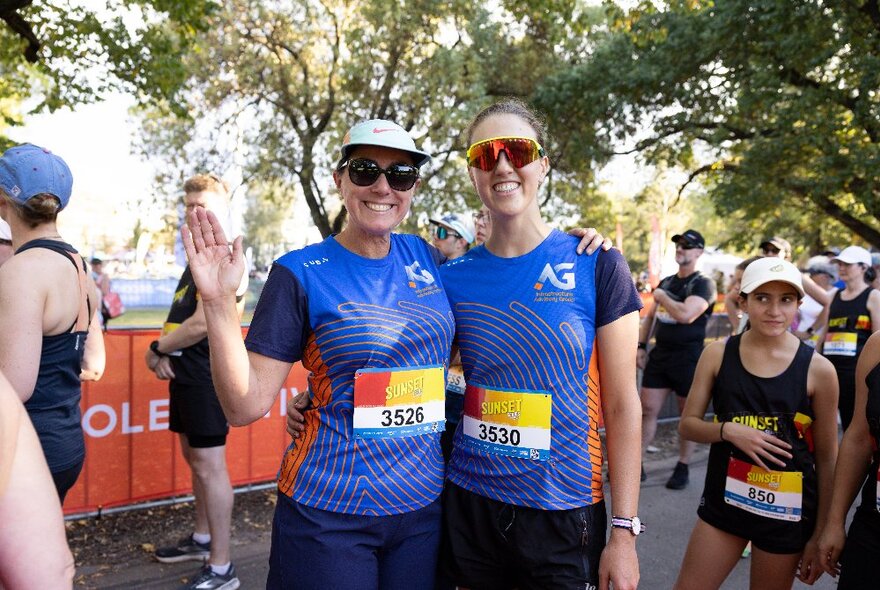 Runners wearing race bibs relaxing and standing around in a park after a race.