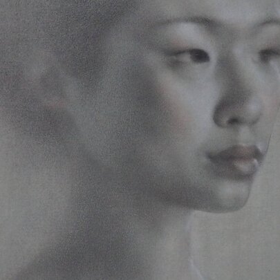 Portrait drawing of a young woman's head in soft grey textures.