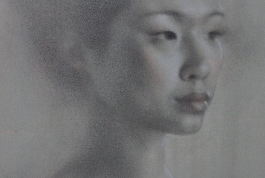 Portrait drawing of a young woman's head in soft grey textures.