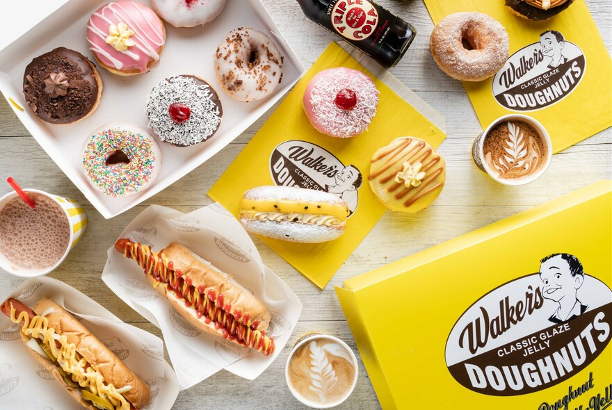 Bird's-eye view of various Walker's products, including box of donuts, shake, hotdogs and coffee.