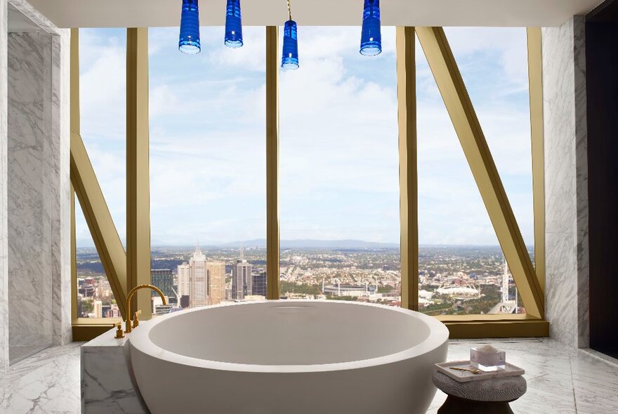 Fancy hotel bath in the Ritz-Carlton, Melbourne with the city below visible through tall windows