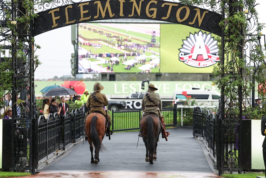 Horses entering Flemington Racecourse under an archway to celebrate Anzac Day.