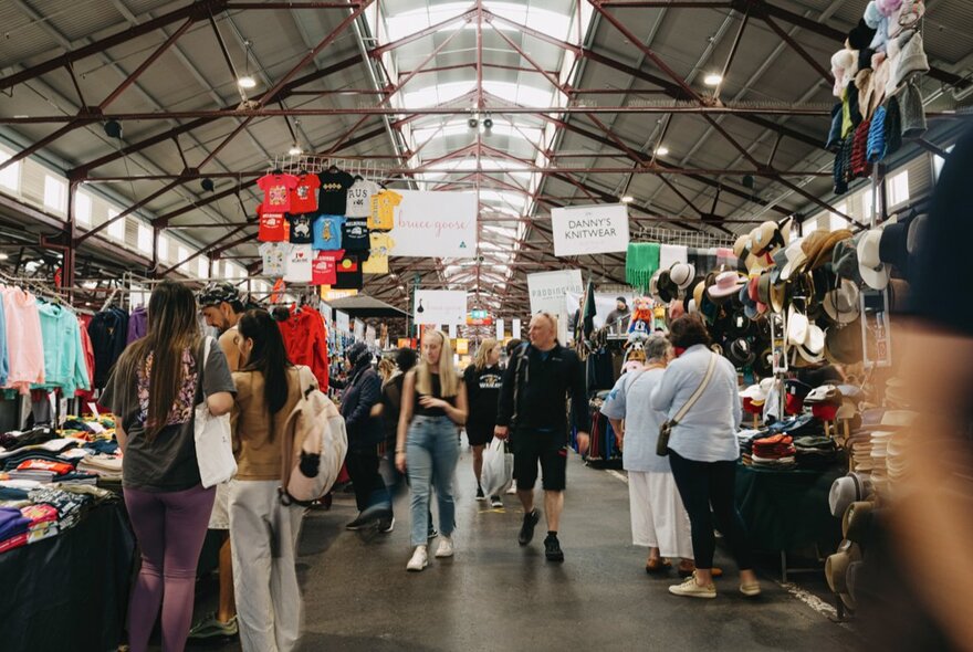 People browsing clothing stalls in the Queen Victoria Market sheds.