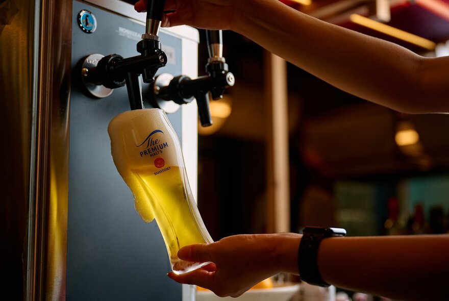 Beer on tap being poured into a large glass.