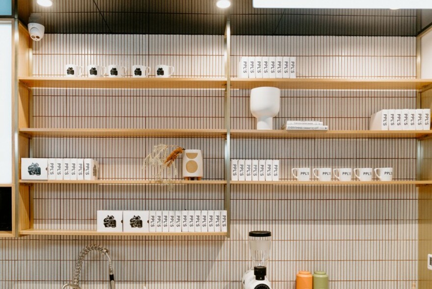 Sparse wooden shelves against white tiles.