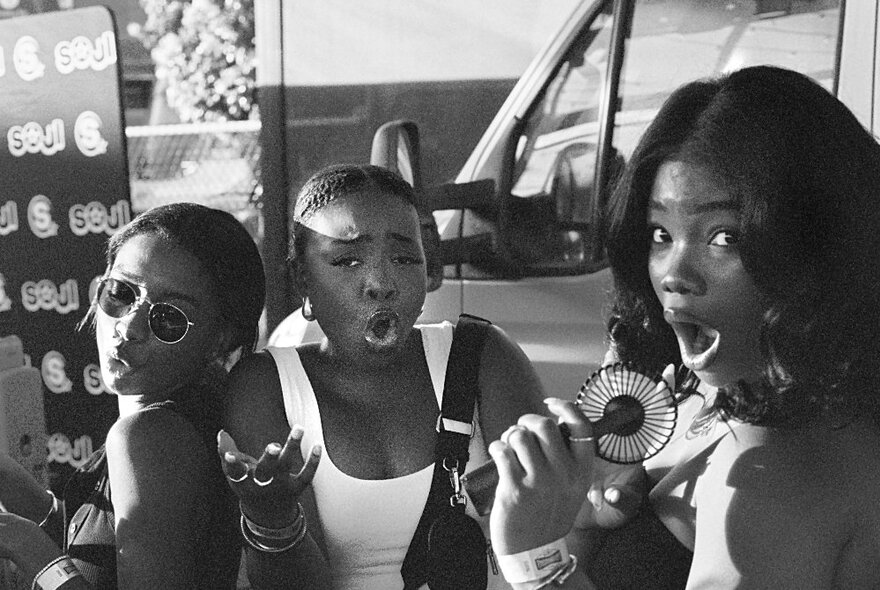 Photojournalism image of three young girls in a car park.