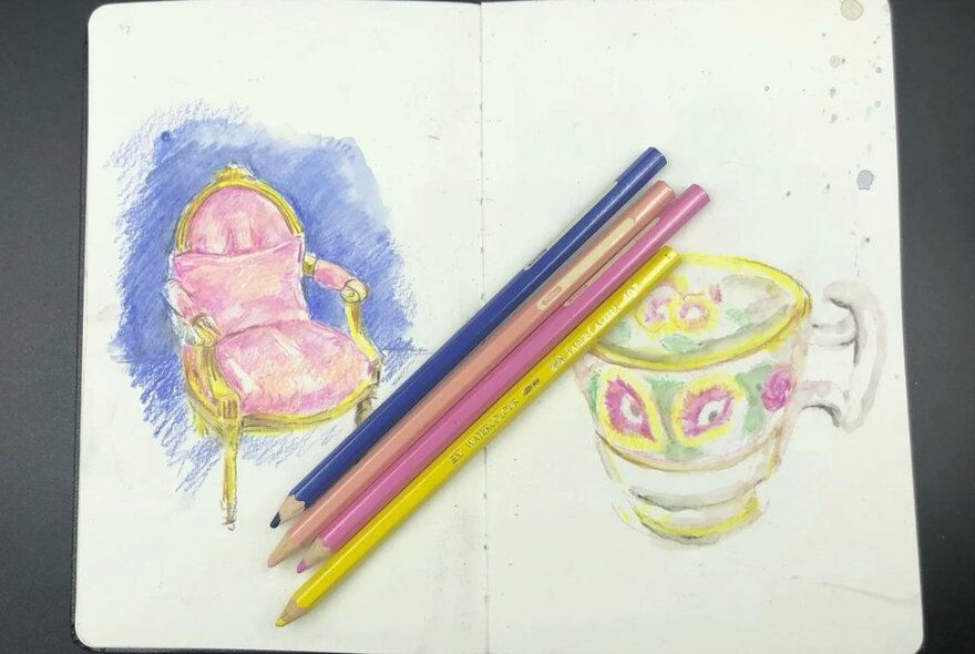 Sketchbook with pencils and drawings of a chair and a cup.
