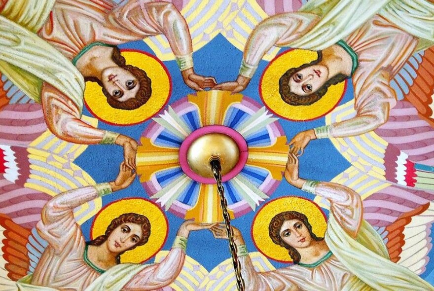 Detail of a painted ceiling with four depictions of Jesus intersecting.