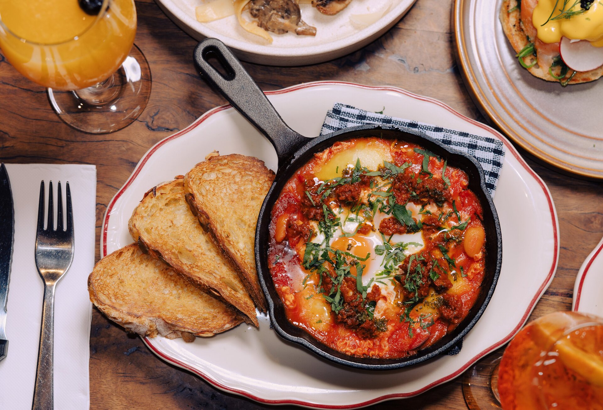 A brunch dish with baked eggs in a cast iron pan and toast.