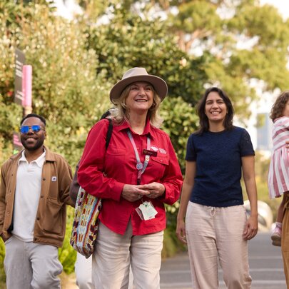 A group of people on a guided walk of the Royal Botanic Gardens, with trees in the background.