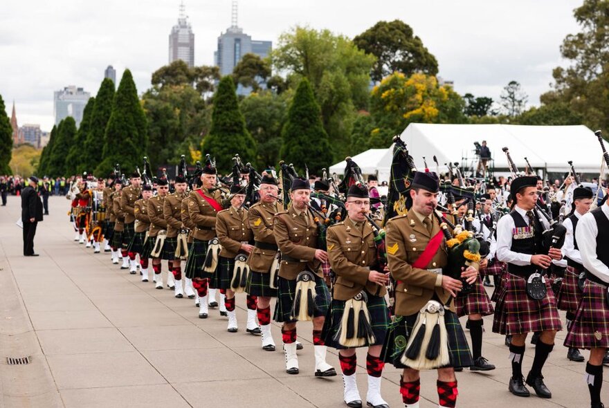 A Scottish pipe band in full uniform on an ANZAC Day march through Melbourne.