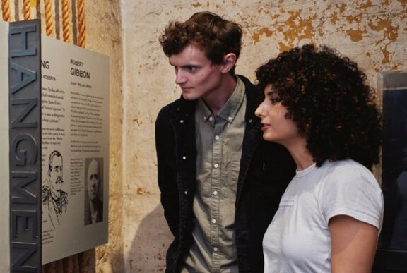 Two young adults looking at a display in the Old Melbourne Gaol.
