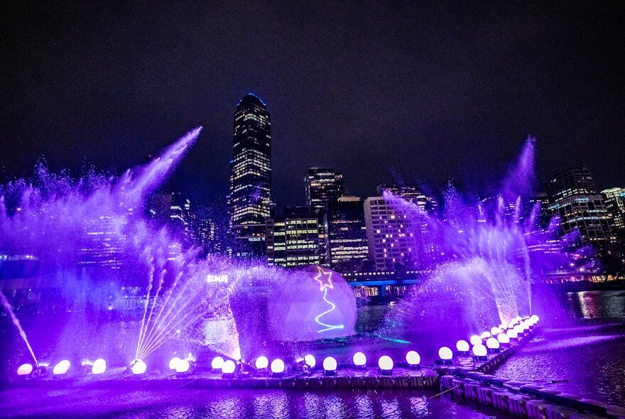 Laser lights and Christmas bauble installation illuminating the Yarra River at night.